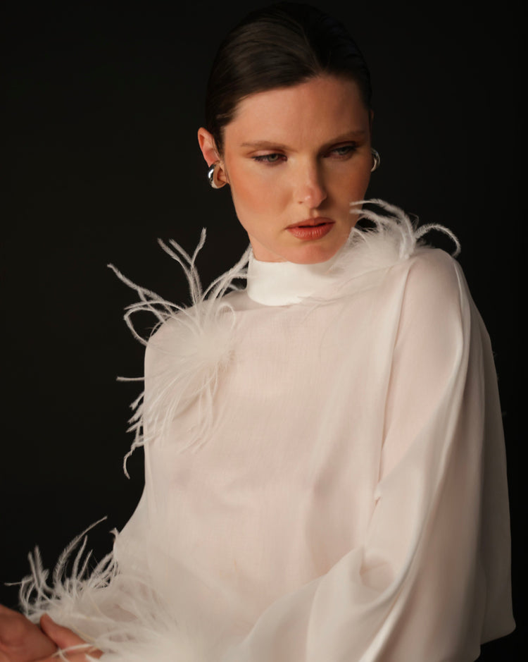 Blusa con bottoni sulla schiena e dettagli in piume